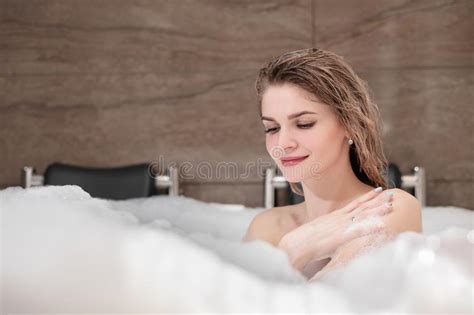 Attractive Blonde Woman Lying In Bathtub In Foam In Hotel Drinking Red
