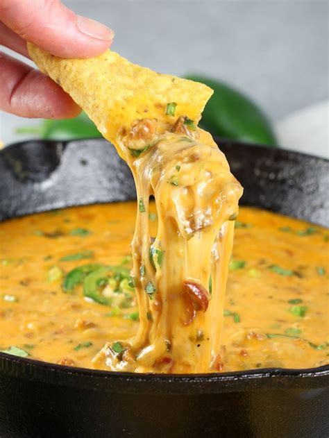 queso fundido with chorizo recipe and image pan with chip dipped close up queso fundido