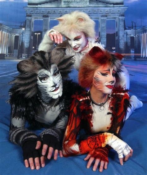 Three People Dressed Up As Cats And Lions Posing For A Photo In Front