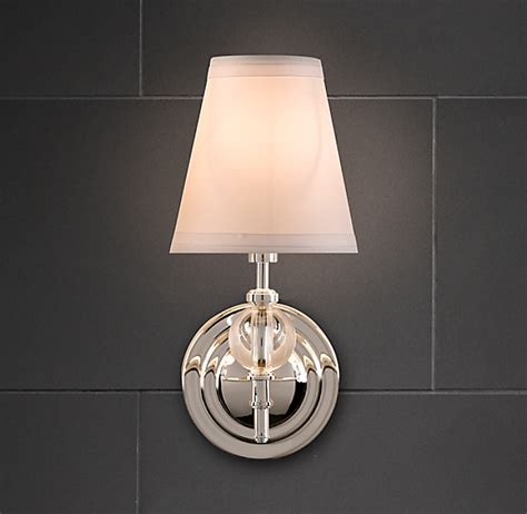 Finished in polished chrome, including a gently undulating frame and a shiny silver wall plate, this wall sconce will certainly brighten up your contemporary bathroom or chic bedroom. Wilshire Single Sconce