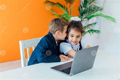 Boy And Girl Sitting At Desk With Laptop Stock Image Image Of