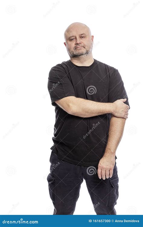 A Serious Bald Middle Aged Man Is Standing Isolated Over White