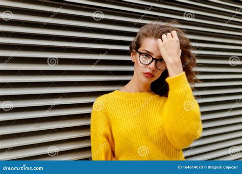 Trendy Hipster Girl In Knited Yellow Sweater In Casual Fashion Outfit And Eyeglass Posicionando