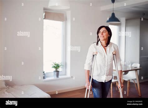 Mature Woman With Crutches Alone At Home Stock Photo Alamy