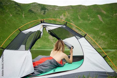 Back View Of Attractive Naked Female Tourist Lying In Tent In Sleeping Bag Enjoying Beautiful