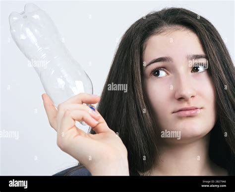 Long Haired Brunette Teen Girl Looking At Empty Plastic Bottle Stock