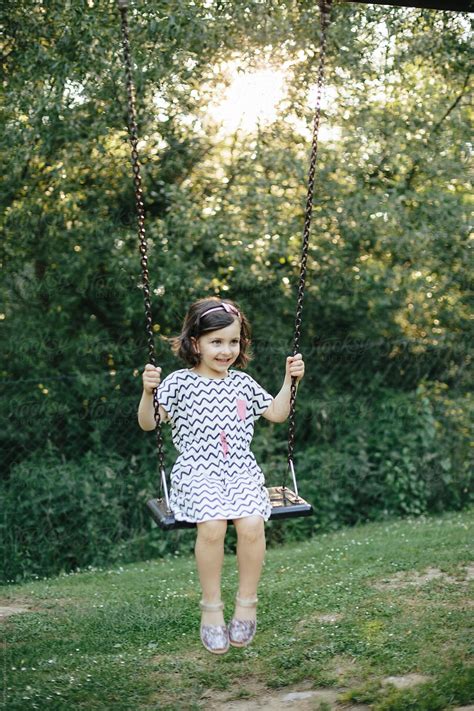 Girl Swinging In The Park By Stocksy Contributor Peter Meciar Stocksy