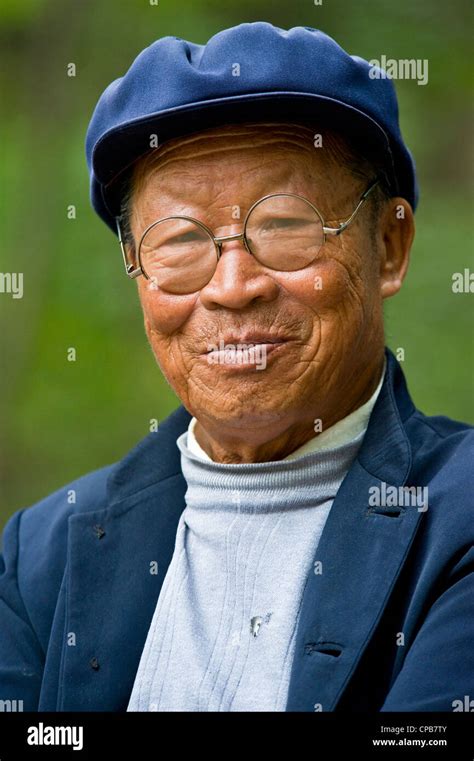 A Elderly Chinese Man Dressed In Traditional Clothes With Round