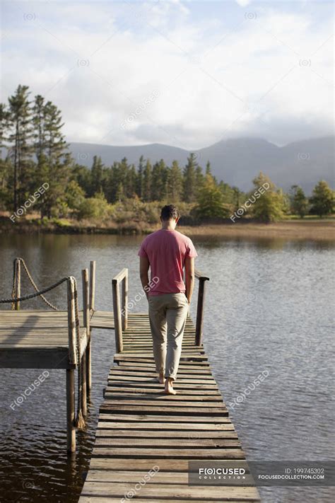 Man Walking Along Dock Over Lake — Waterfront Hands In Pockets Stock