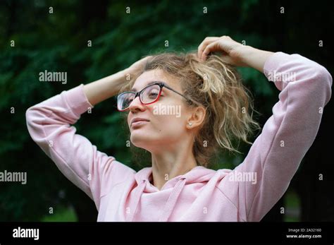 Outside Portrait Of Blonde Girl With Hipster Eyeglasses In Pink Clothes