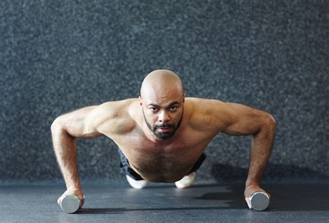 Free Photo Strong Man Pushing Up On Dumbbells With Effort