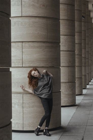 Carefree Caucasian Woman Leaning On Pillar Photo12 Tetra Images Ivan Ozerov