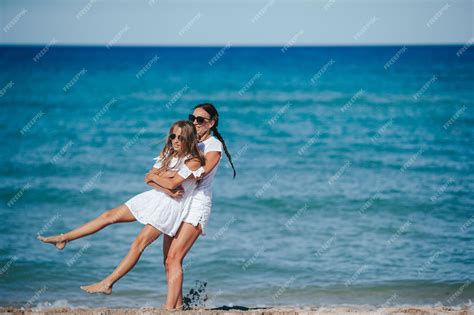 Premium Photo Young Happy Mother And And Her Daughter Having Fun On The Beach