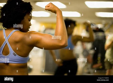 Young Woman Flexing Her Muscles At A Gym Stock Photo Alamy