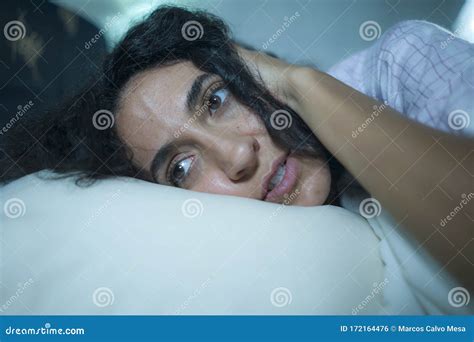 Young Sad And Depressed Hispanic Woman With Curly Hair Sleepless In Bed Awake And Thoughtful
