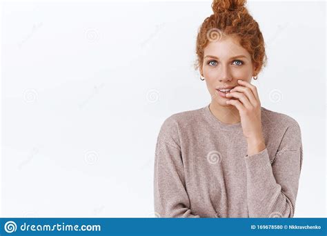 Sensual Gorgeous Feminine Redhead Curly Woman With Combed Hair In Bun Touching Lip And Look