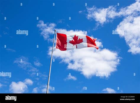 Canadian Flag Waving Against Clouds Background Stock Photo Alamy