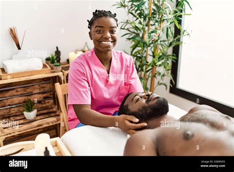 Young Physiotherapist Woman Giving Head Massage To African American Man At The Clinic Stock