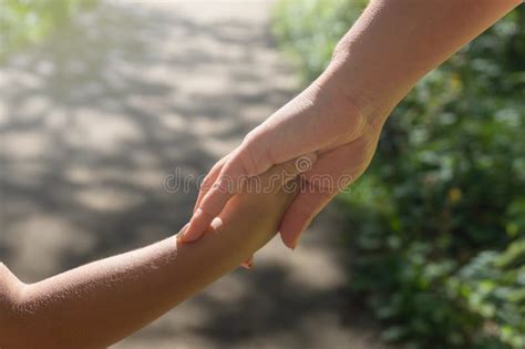 Mother And Child Hold Hands On A Walk In The Park Stock Image Image