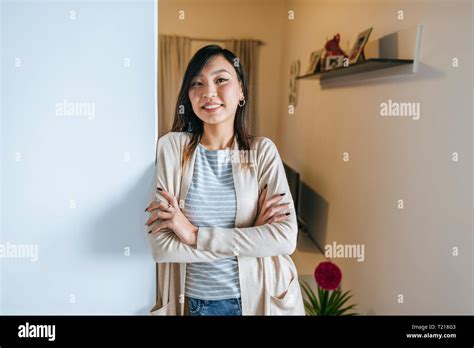 Confident Woman Leaning Against Wall With Arms Crossed Portrait Stock