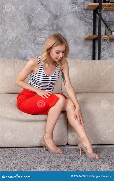 Woman In Fashionable Short Dress Skirt High Heels Sitting On Couch