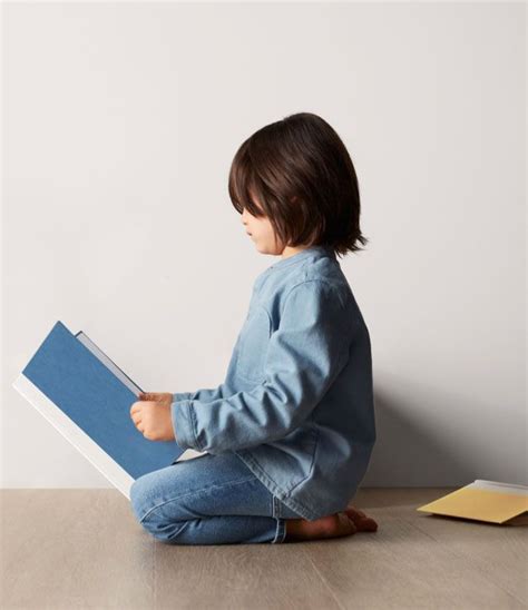 A Child Sitting On The Floor Reading A Book In 2020 Free Online