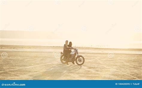 Attractive Young Woman Motorcyclist With His Girlfriend Riding A Motorcycle In A Desert On