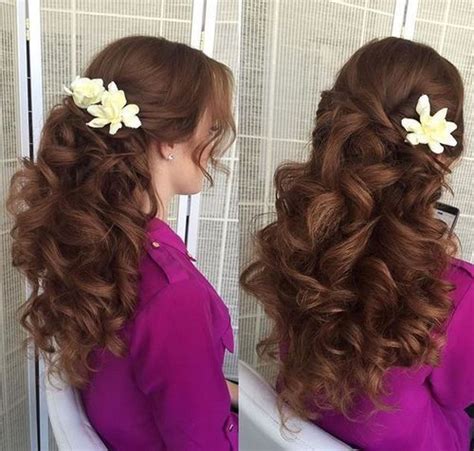 A Woman With Long Curly Hair And Flowers In Her Hair Is Shown From The Side