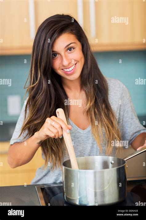 Beautiful Young Woman Cooking Dinner At Home In Kitchen Lifestyle