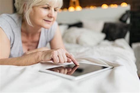Free Photo Mature Woman Using Tablet In Bedroom