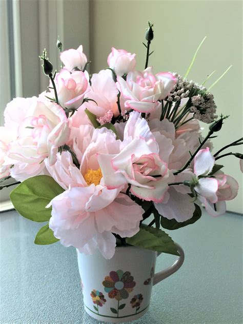 A Bouquet Of Pink Flowers In A Coffee Cup