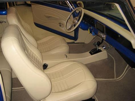 The Interior Of An Old Car With White Leather Seats And Blue Trims On It