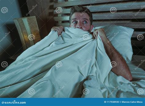 Sleepless Young Man Lying In Bed Stressed And Scared Suffering