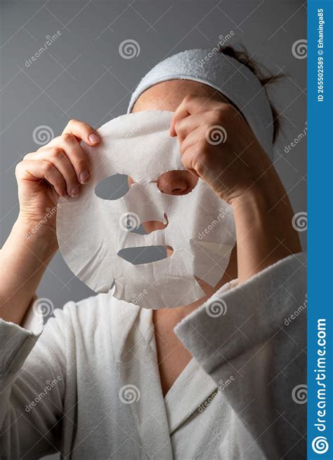 woman applying textile face mask skin care moisturising cosmetic procedure stock image