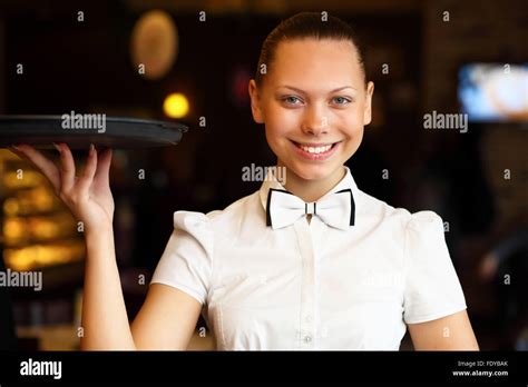 Portrait Of Young Waitress In White Blouse Holding A Tray Stock Photo
