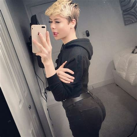 A Woman Taking A Selfie In Front Of A Mirror With Her Hand On Her Hip