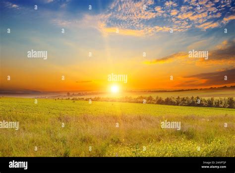 Wide Landscape Of Green Field And Epic Sunset Stock Photo Alamy