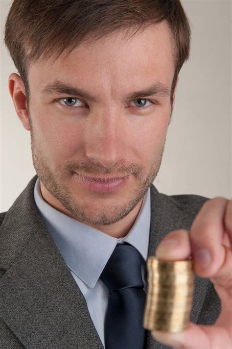 Successful Businessman Holds A Pile Of Coins In Front Of Him Stock