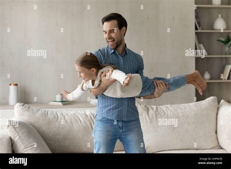 Cheerful Excited Dad Holding Happy Daughter Kid In Arms Stock Photo Alamy