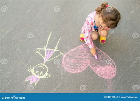 The Child Paints Chalk On The Asphalt Heart Selective Focus Stock