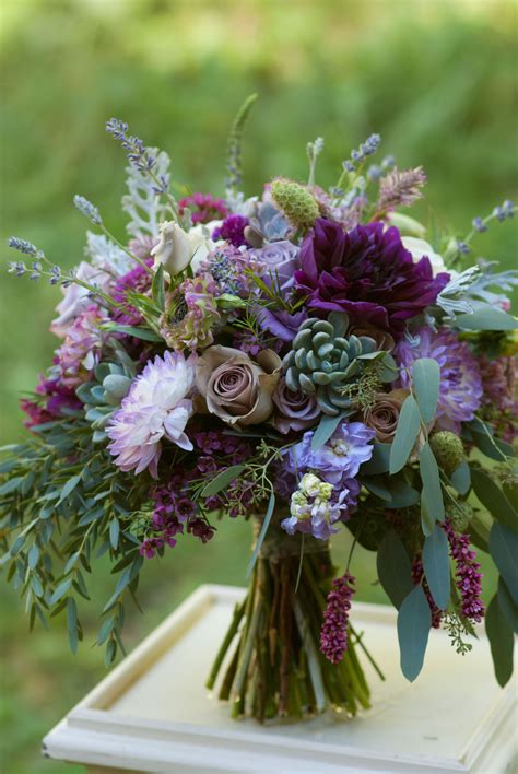 plum and lavender bridal bouquet featuring dahlias roses succulents and lots of fragr