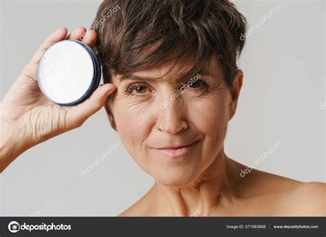 Madura Mujer Semidesnuda Sonriendo Mientras Muestra Crema Facial Aislada Sobre Fotograf A De