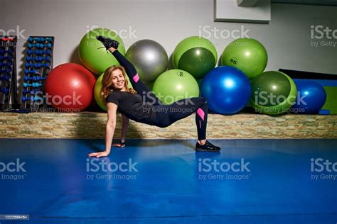 Slim Athletic Young Woman In Black Sportwear Does Sport Gymnastics