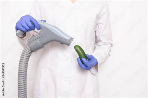 doctor holds a cucumber near the vacuum cleaner on a white background the concept of increasing