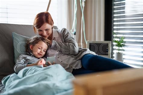 happy small girl with mother in bed in stock image colourbox