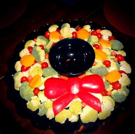 Imagine serving just a simple casserole and garlic bread for christmas. Vegetable tray bouquet for Christmas dinner! The bow is made of red peppers. #vegetables # ...