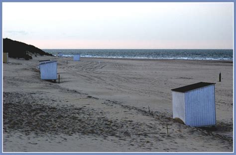 Foto über frau, die auf dem leeren strand steht. ..die Buden sind geschlossen - der Strand ist leer... Foto ...