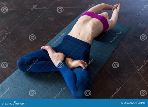 Flexible Young Woman Lying On Floor Doing Stretching Exercise For Body