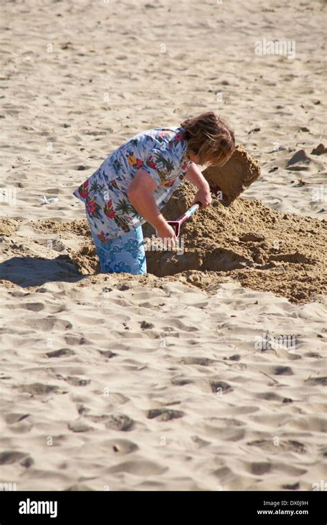 Man Digging A Deep Hole In The Sand At Bournemouth Beach Bournemouth