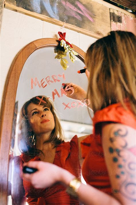 Girl Writing Merry X Mas On The Mirror Del Colaborador De Stocksy